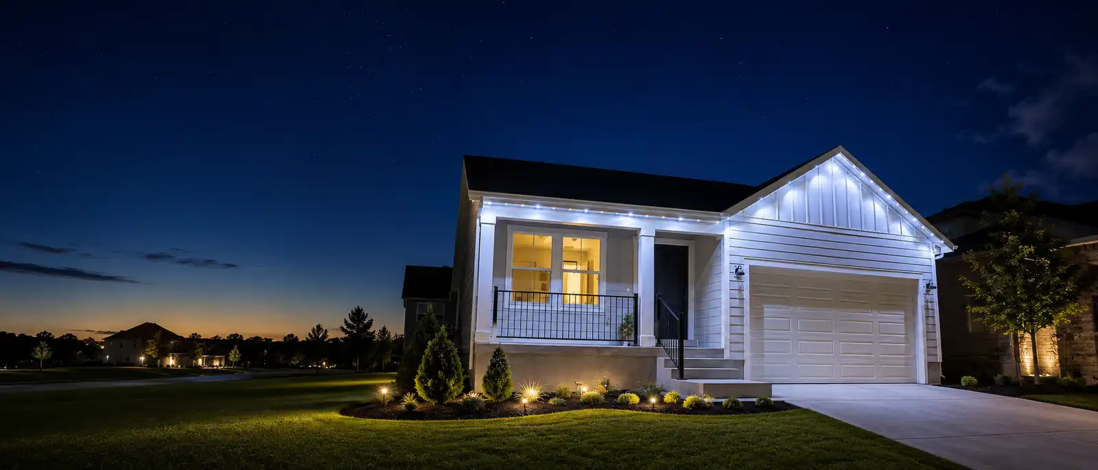 White Utah home with permanent LED roofline lighting and landscape accents at night